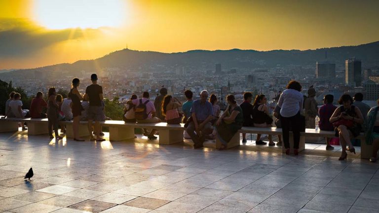 Turister tittar på solnedgången över Barcelona.