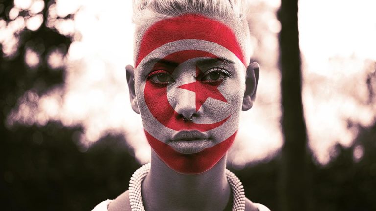 Woman with Tunisian flag painted on face.