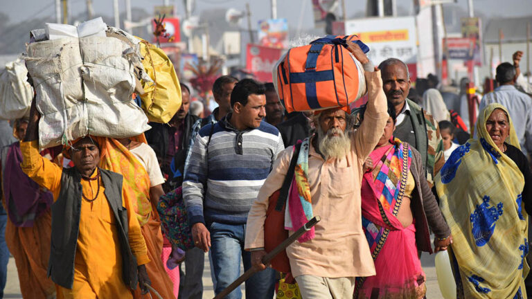 Människor i Indien som förlorat sina jobb vandrar hemåt